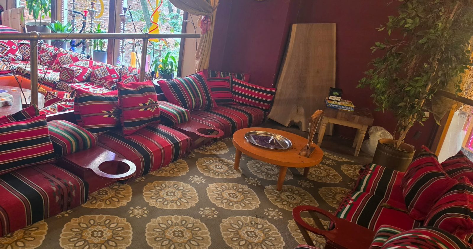 Cozy corner with striped Arabic floor cushions and a low wooden table