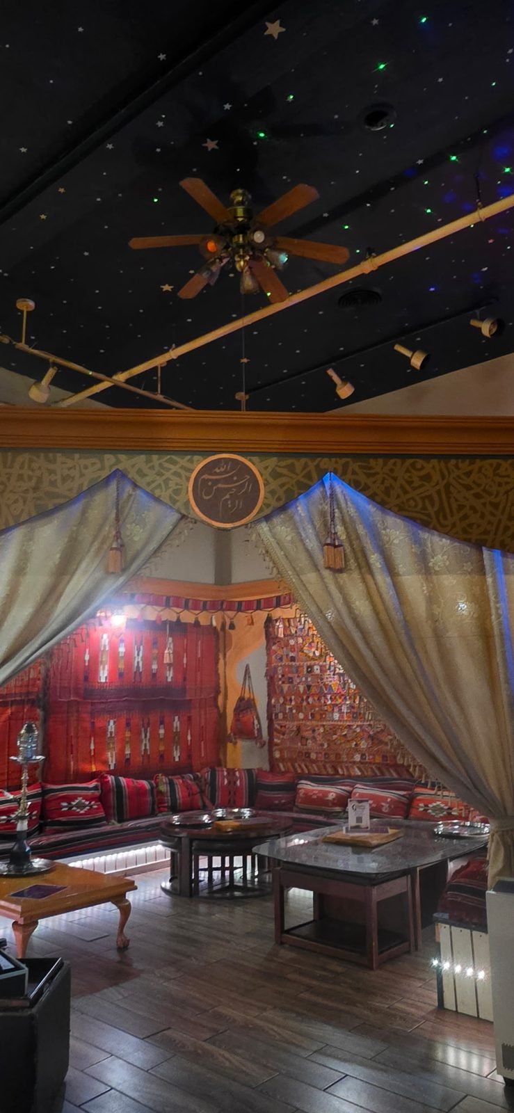 Tented seating area under a starry ceiling with woven rugs